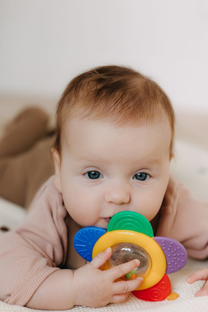 why-choose-us Cute baby playing with a colorful teething toy, perfect for parenting and lifestyle themes.